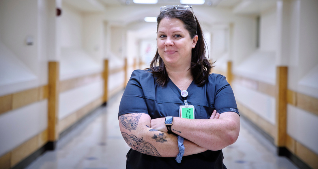 Respiratory Therapist smiling in hospital hallway.
